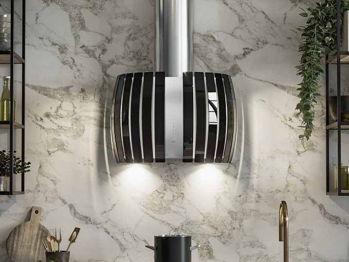 A black and silver hood is hanging from the ceiling in a kitchen.