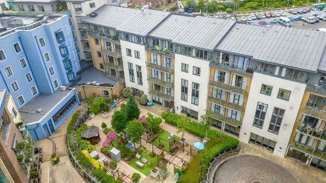 Aerial view of apartment buildings with a small courtyard garden in the center.