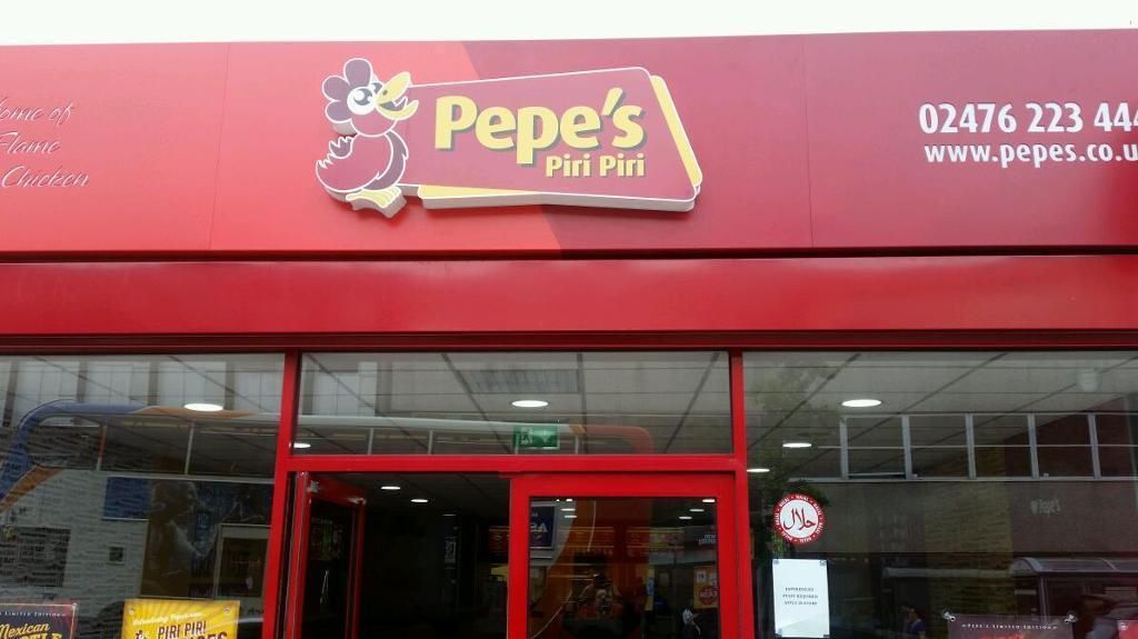 Pepe's Piri Piri restaurant exterior with red facade, signage, and open door.