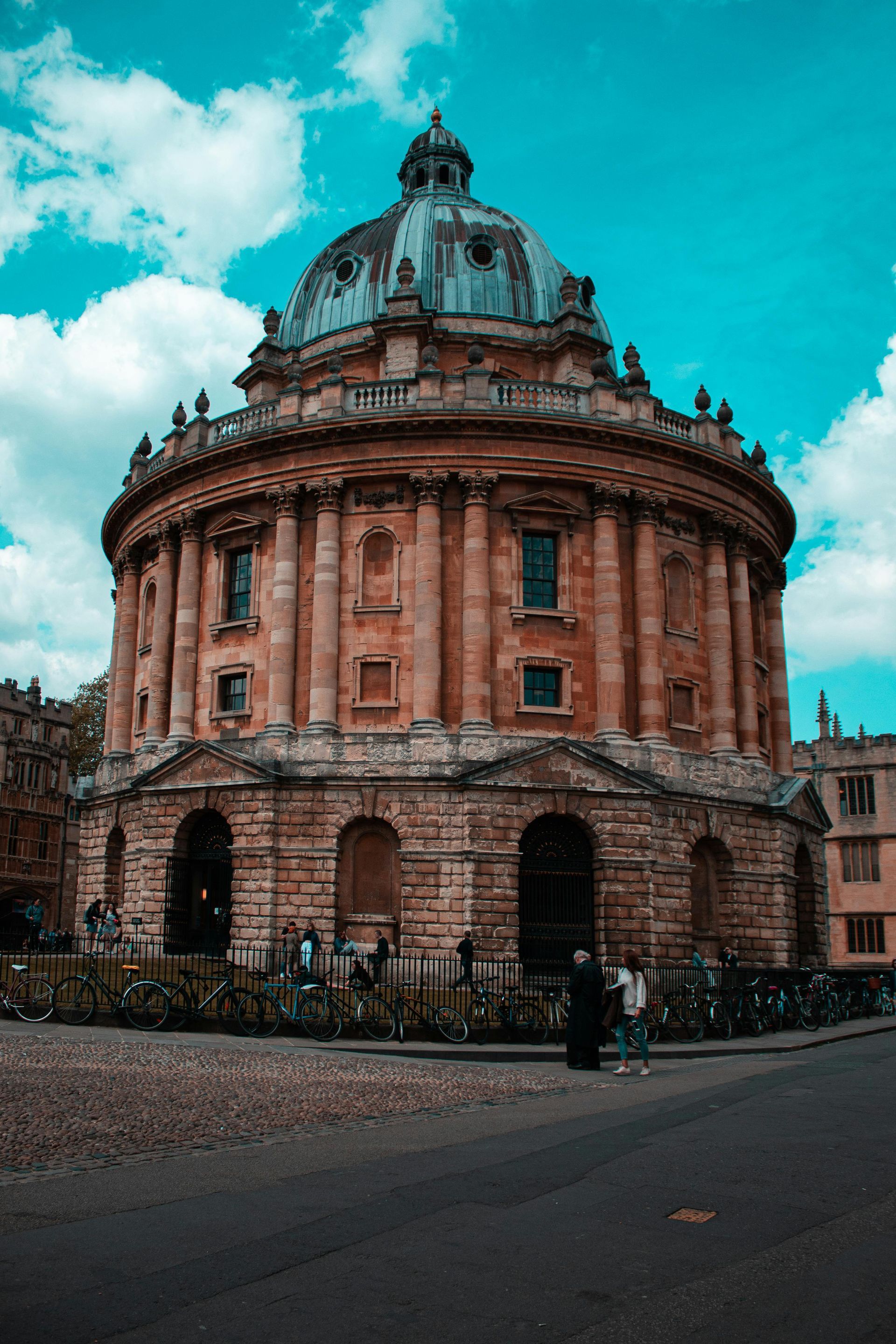 Radcliffe Camera, Oxford, a domed circular building made of stone, under a blue sky with clouds.