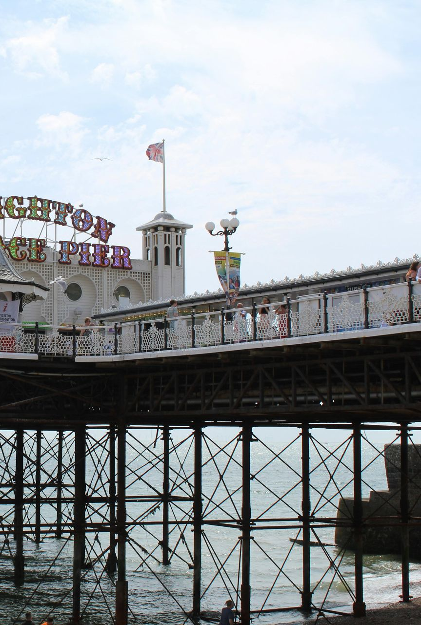 Brighton Pier, seaside structure with a tower and a British flag, over ocean.