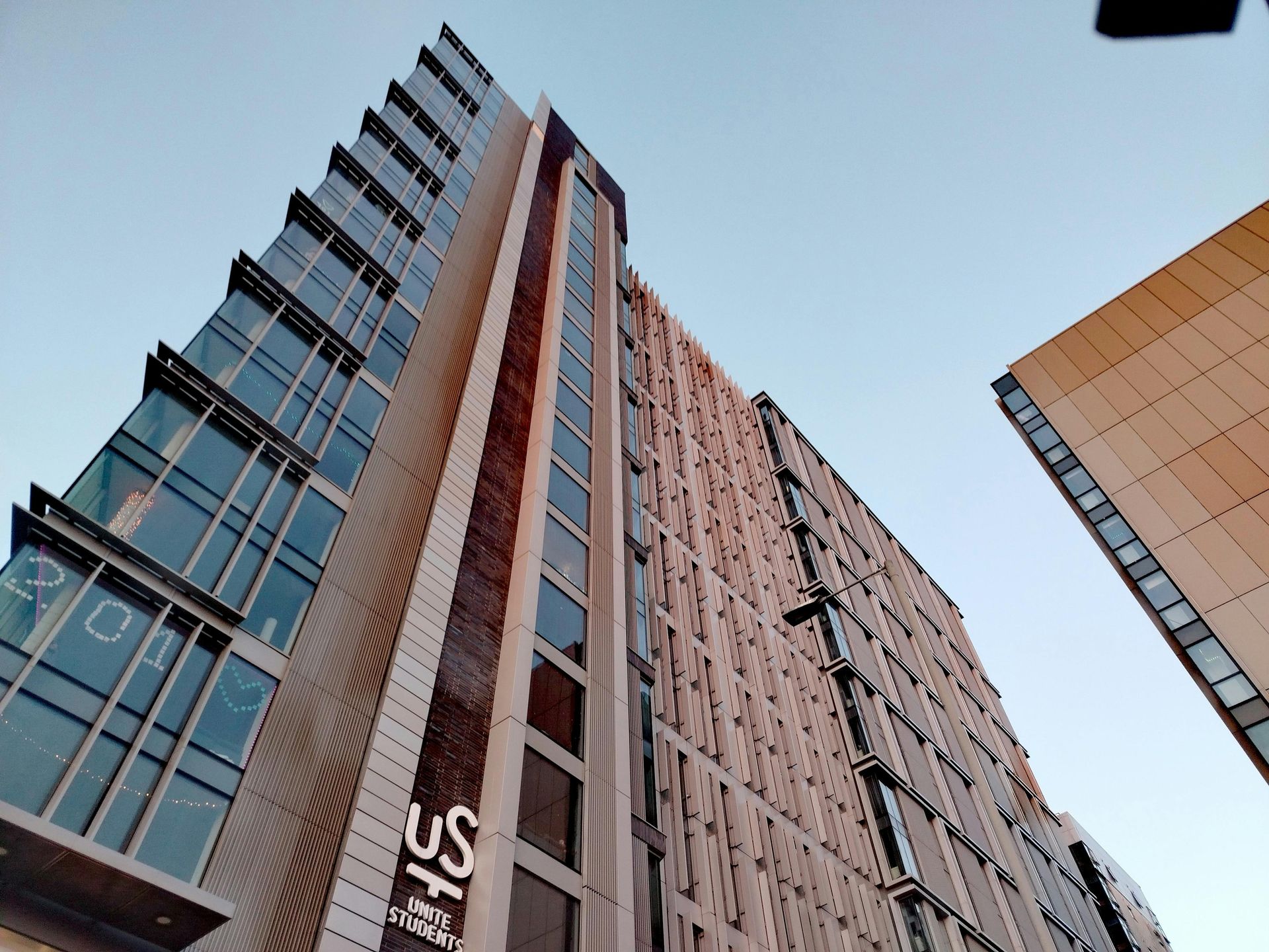 Modern skyscraper, blue sky background, upward angle.