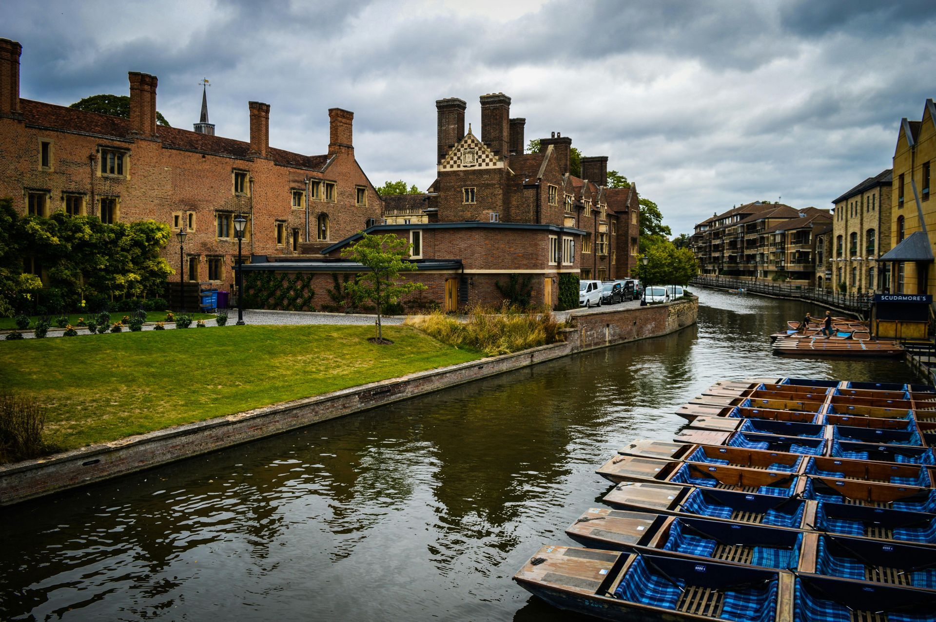 River Cam with punts and buildings along the bank under a cloudy sky.
