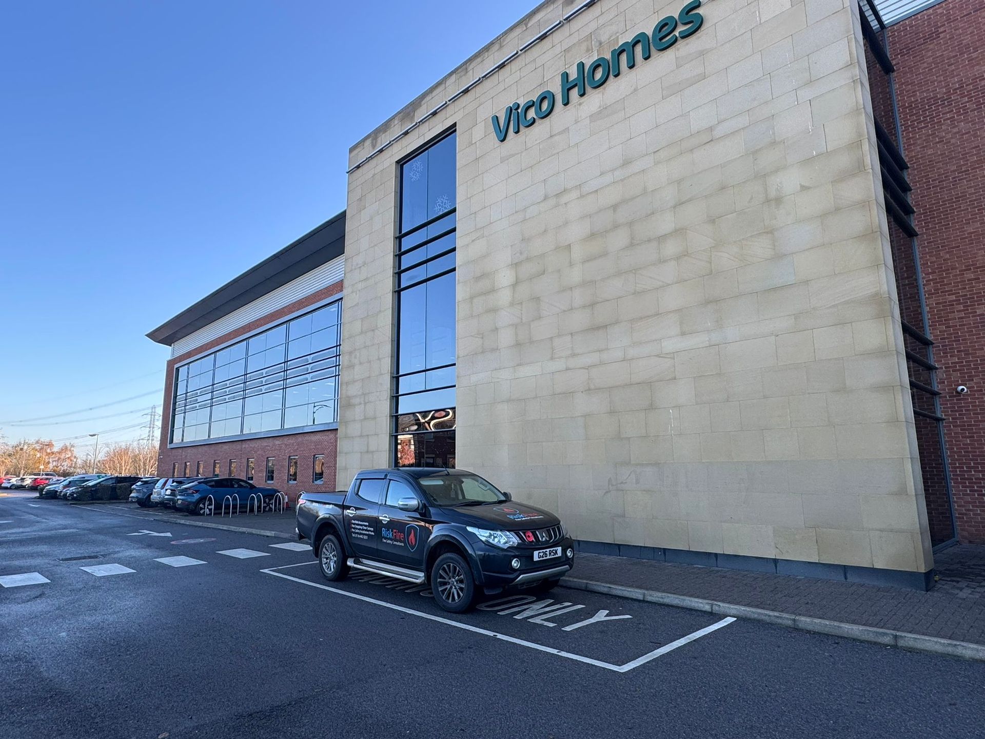 Exterior of Vico Homes building with a dark pickup truck parked in front.