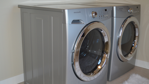 Front-loading silver washer and dryer side by side in a laundry room
