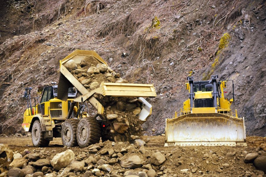 Yellow Dump Truck Unloading Rocks Next to a Bulldozer at a Construction Site — STJ Earthmoving in Georgetown, QLD