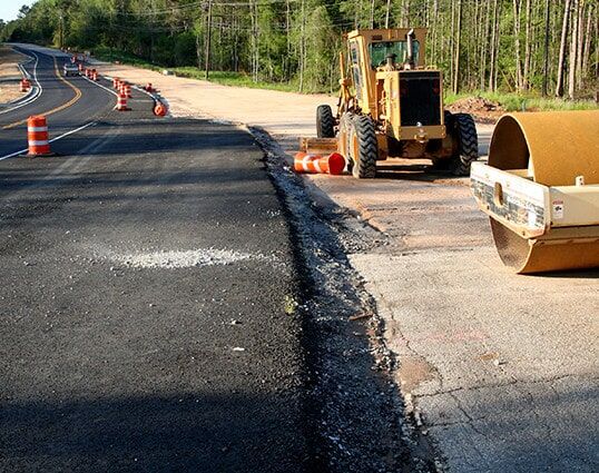 A Roller is Sitting on the Side of a Road Next to a Bulldozer — STJ Earthmoving in Mareeba, QLD