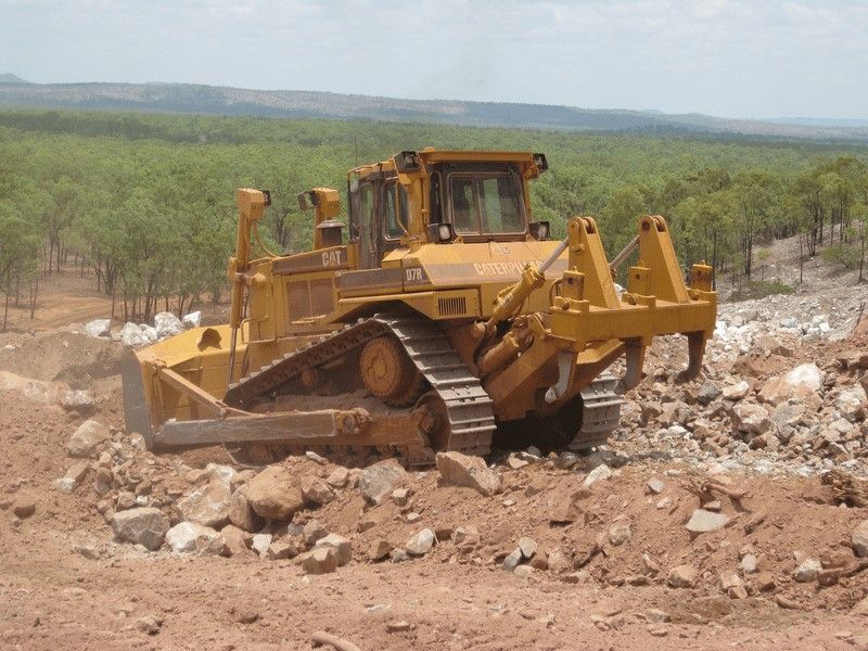A Bulldozer is Moving Dirt and Rocks in a Field — STJ Earthmoving in Mareeba, QLD