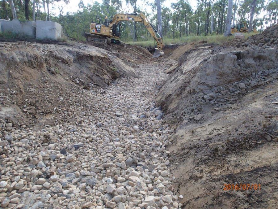 A Bulldozer is Digging a Hole in a Pile of Rocks — STJ Earthmoving in Mareeba, QLD