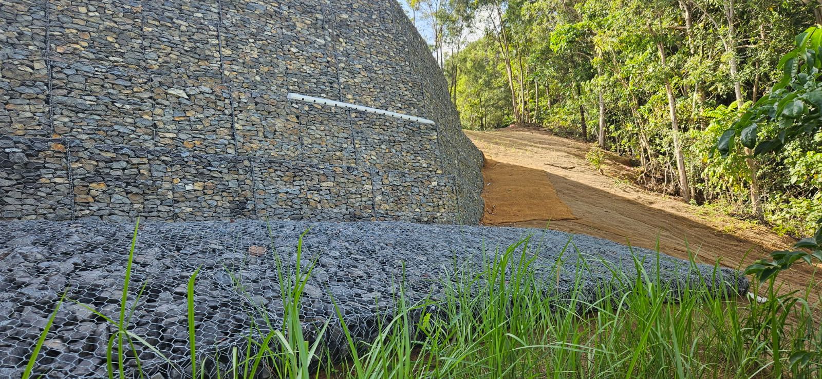 Gabion Wall Made of Rocks, with a Gravel Path Leading Into Trees — STJ Earthmoving in Georgetown, QLD