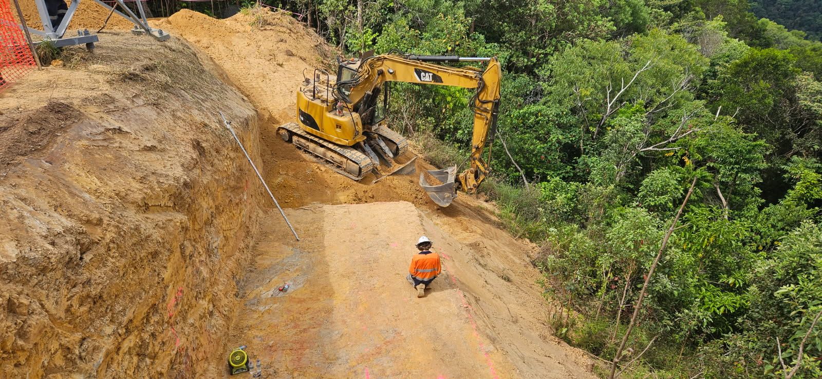 A Bulldozer is Moving a Large Rock in the Dirt — STJ Earthmoving in Mareeba, QLD