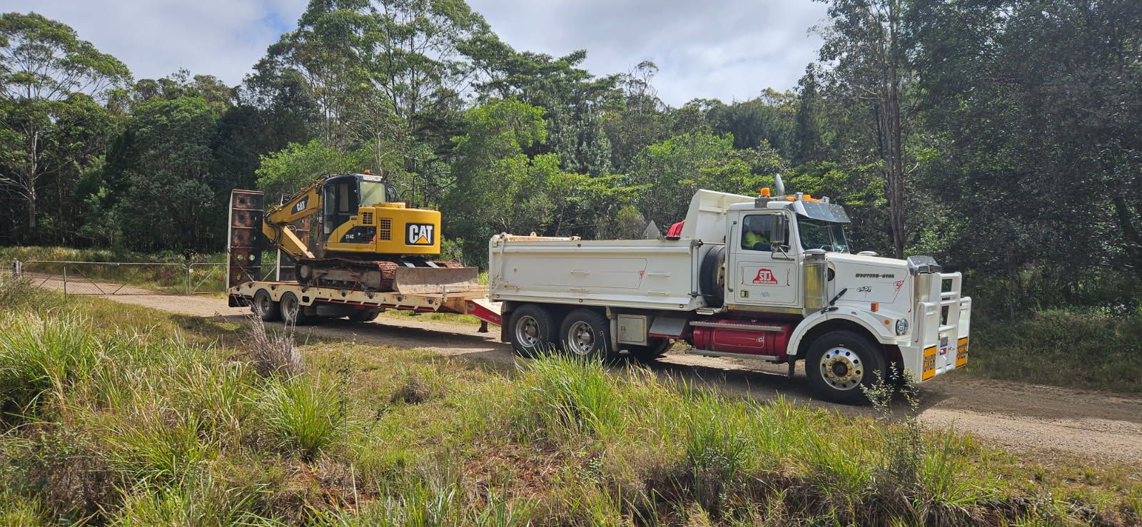 A Man is Standing Next to a Bulldozer in the Woods — STJ Earthmoving in Mareeba, QLD