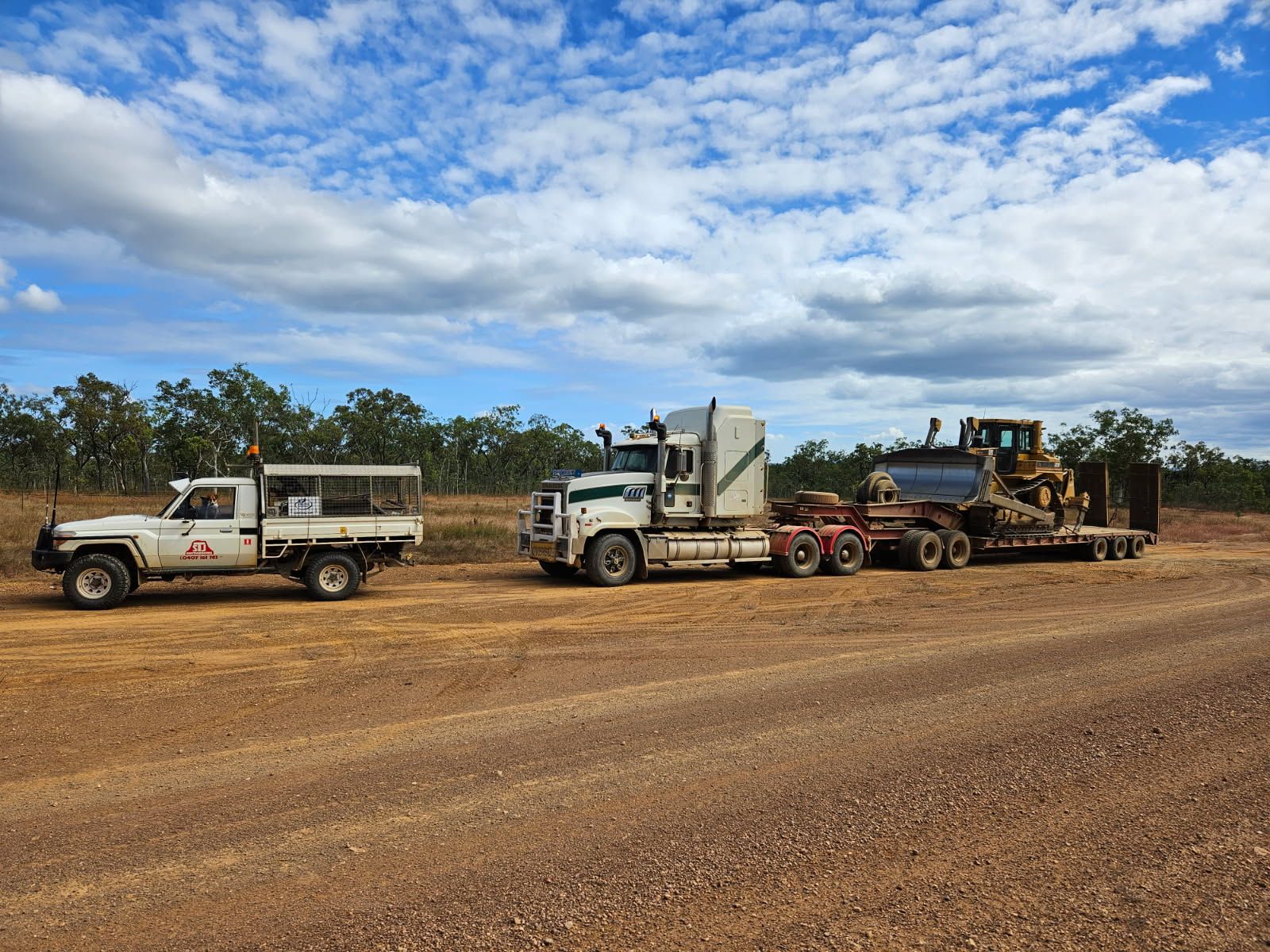 A Man is Standing Next to a Dump Truck Filled With Dirt — STJ Earthmoving in Mareeba, QLD