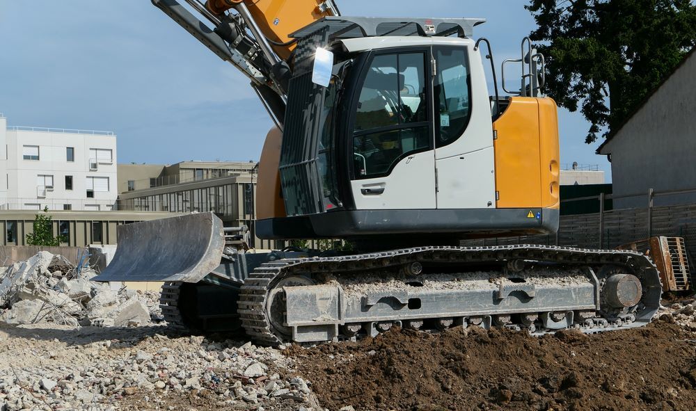 A Large Excavator is Driving Through a Pile of Dirt — STJ Earthmoving in Mareeba, QLD
