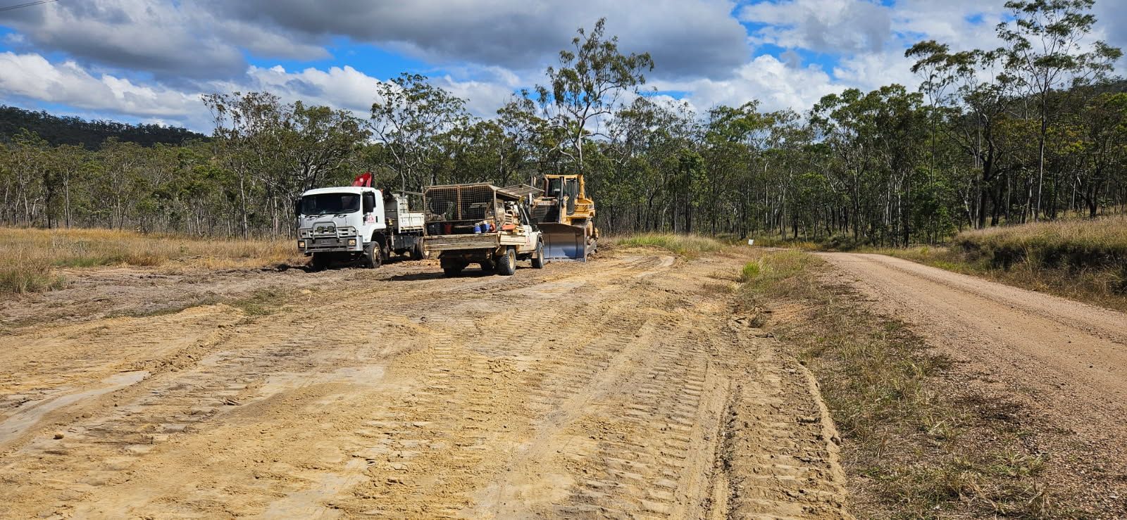 Construction Site With a White Truck, Bulldozer, and Dirt Road in a Field — STJ Earthmoving in Cooktown, QLD