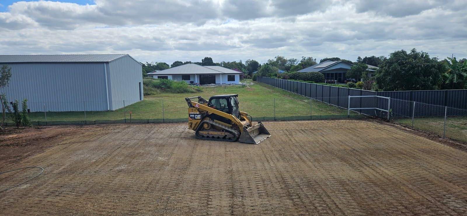 A Yellow Caterpillar Skid Steer on a Cleared Plot of Land — STJ Earthmoving in Julatten, QLD