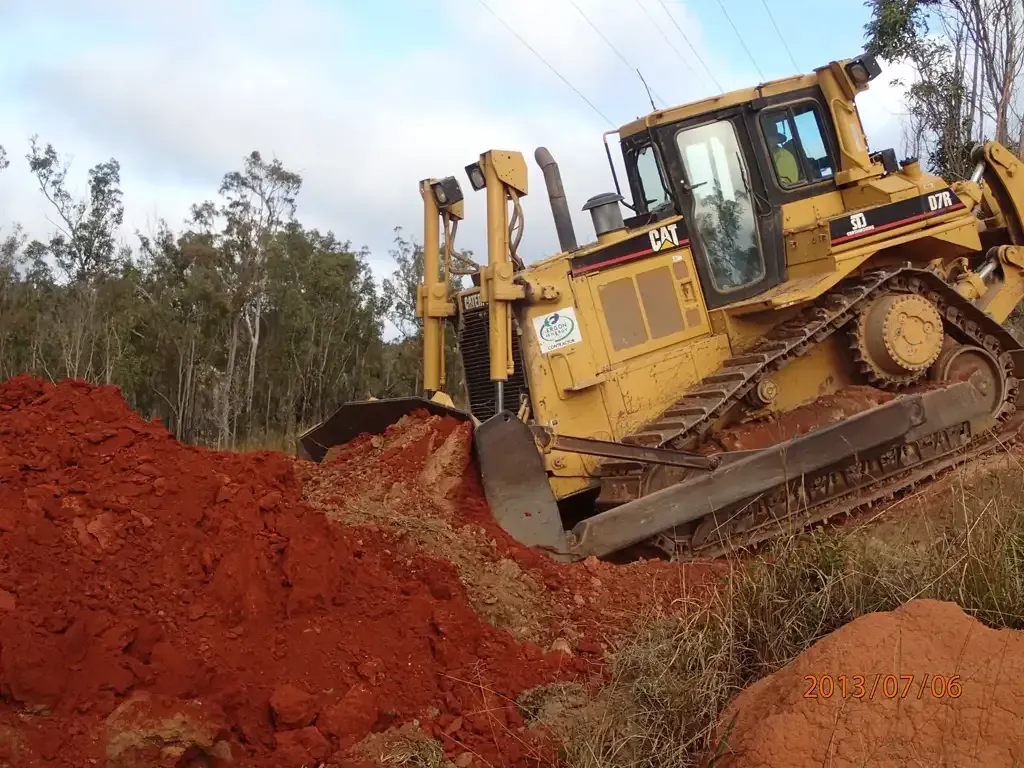 Yellow Bulldozer Pushing Red Soil — STJ Earthmoving in Hann River, QLD