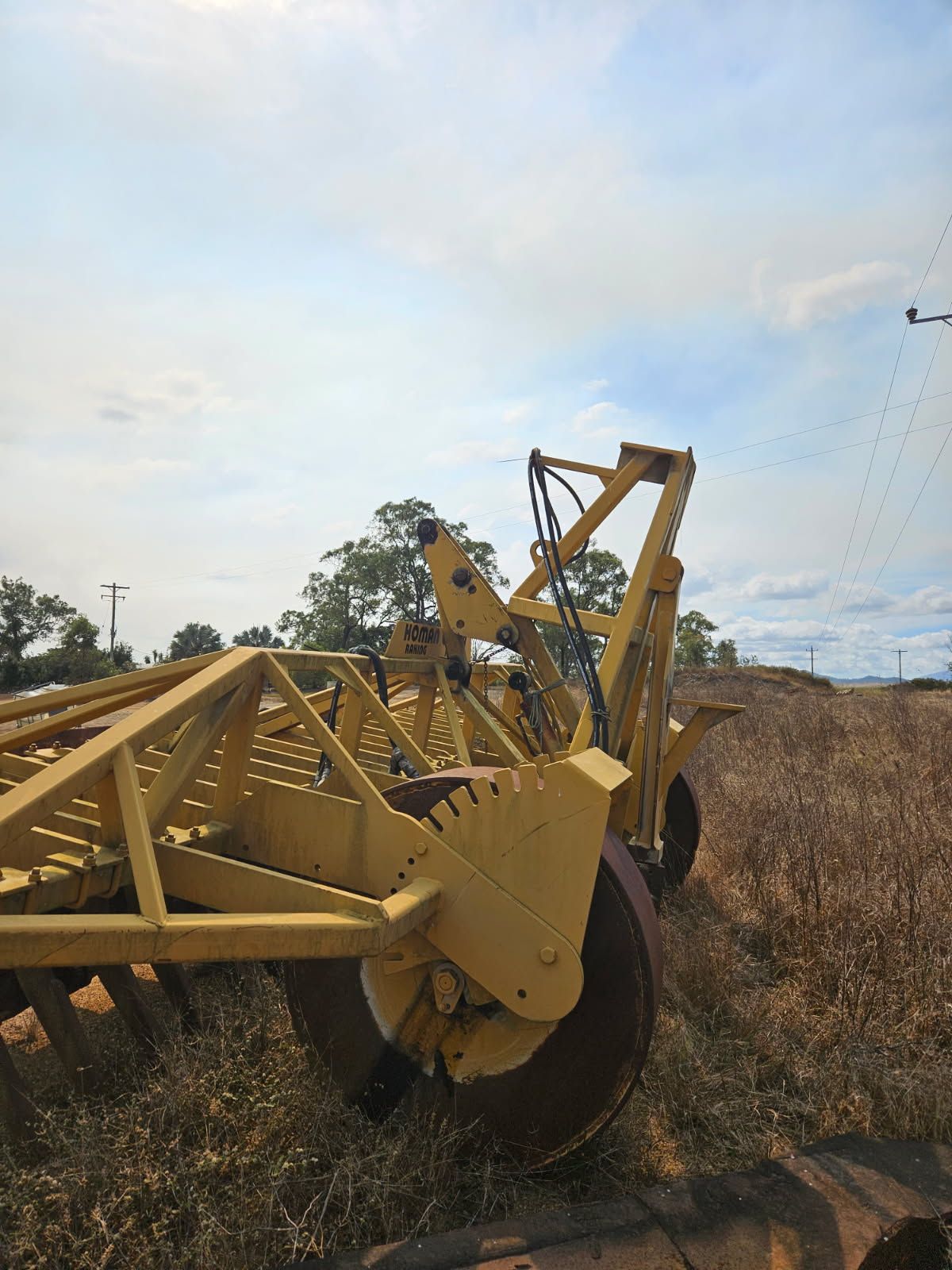 Yellow Agricultural Disc Harrow in a Field Under a Cloudy Sky — STJ Earthmoving in Kowanyama, QLD