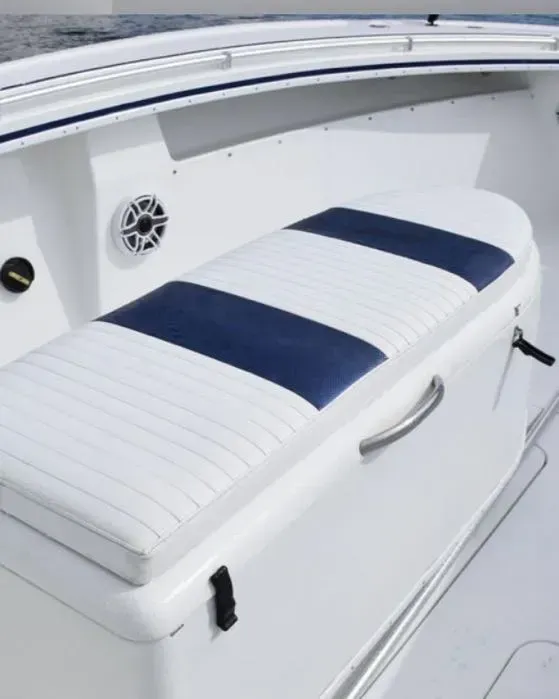 A white boat with a blue and white striped seat