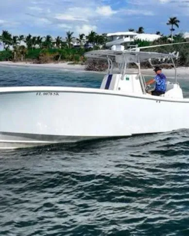 A white boat is floating on top of a body of water.