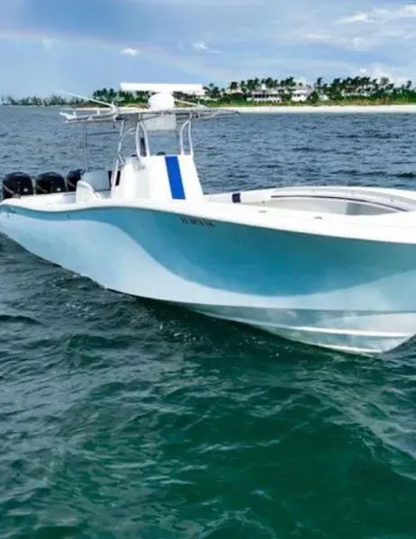A blue and white boat is floating on top of a body of water.