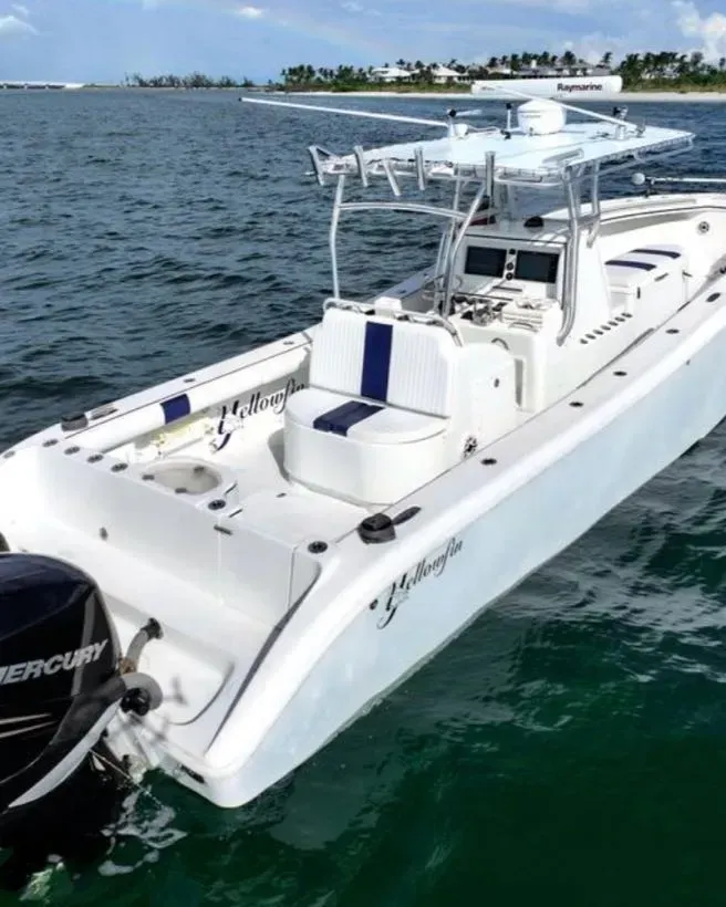 A white boat with a mercury engine is in the water
