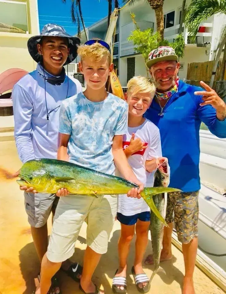 A group of people standing next to each other holding a large fish.