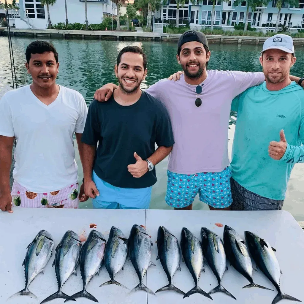 A group of men standing around a table with fish on it