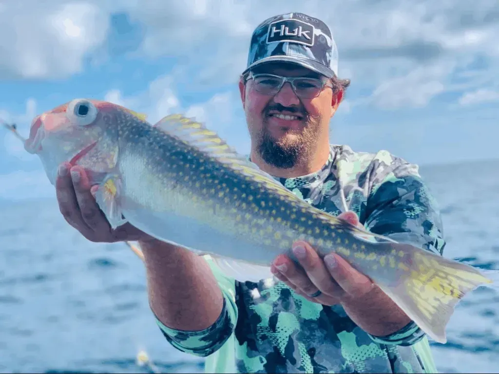 A man is holding a fish in his hands on a boat.