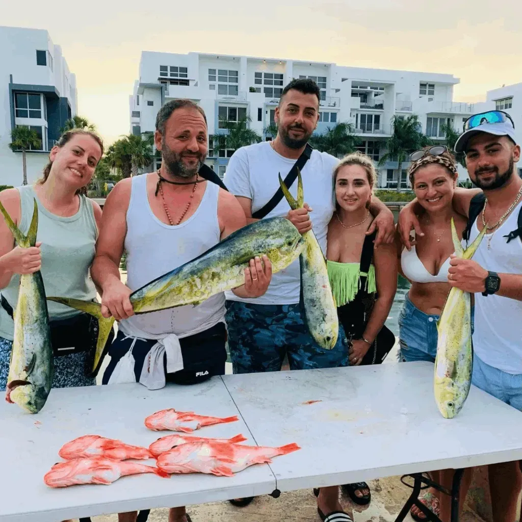 A group of people standing around a table holding fish