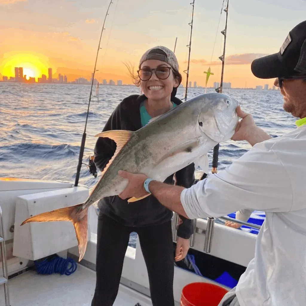 A man and a woman are holding a large fish on a boat.