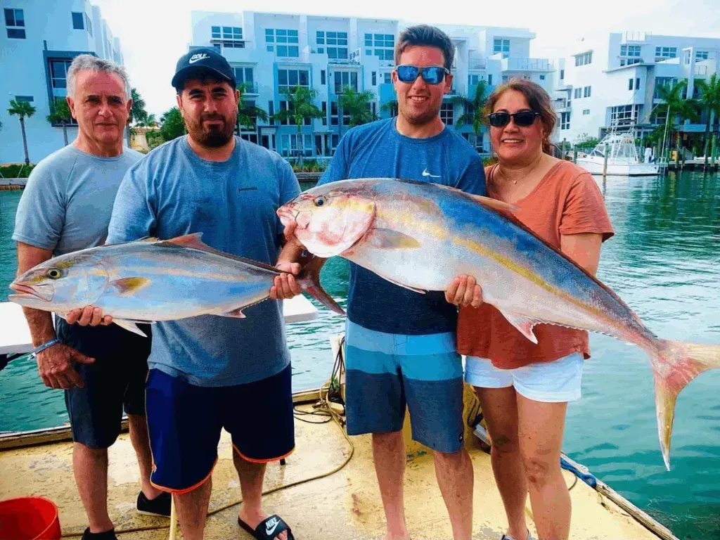 A group of people holding large fish on a boat
