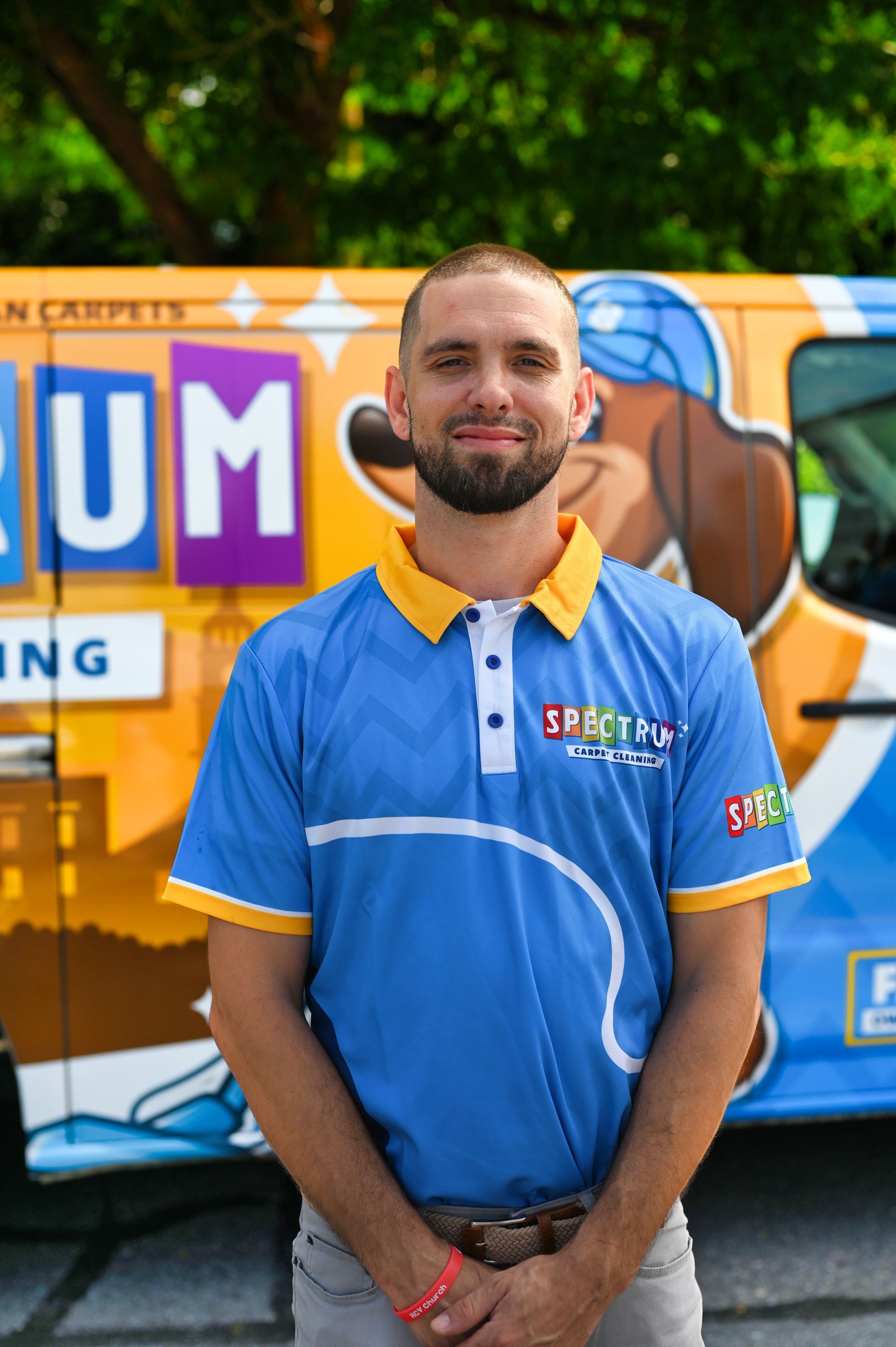 A man with a beard is standing in front of a spectrum van.