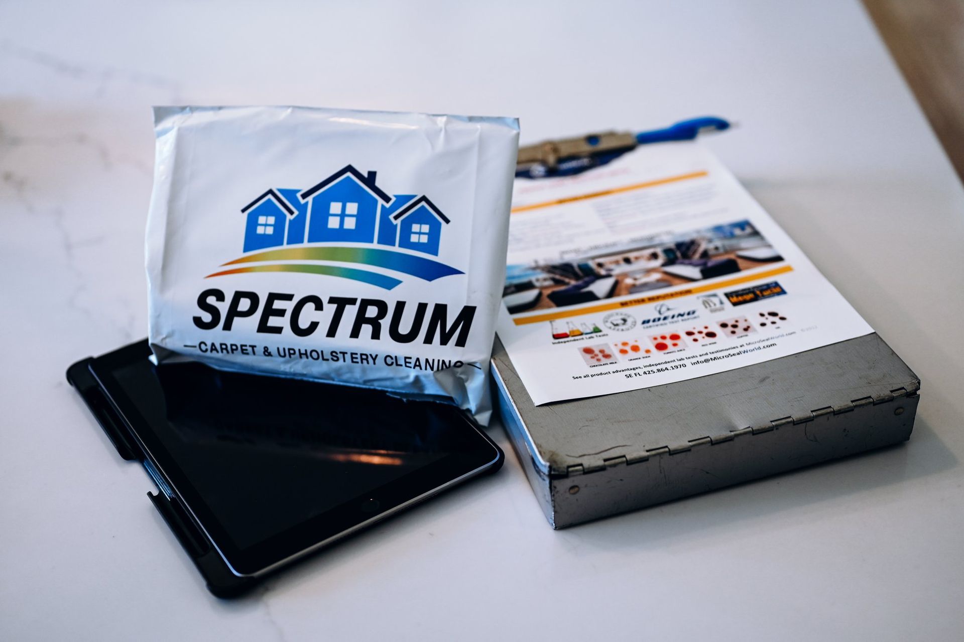 A packet of spectrum wipes is sitting on a table next to a tablet.