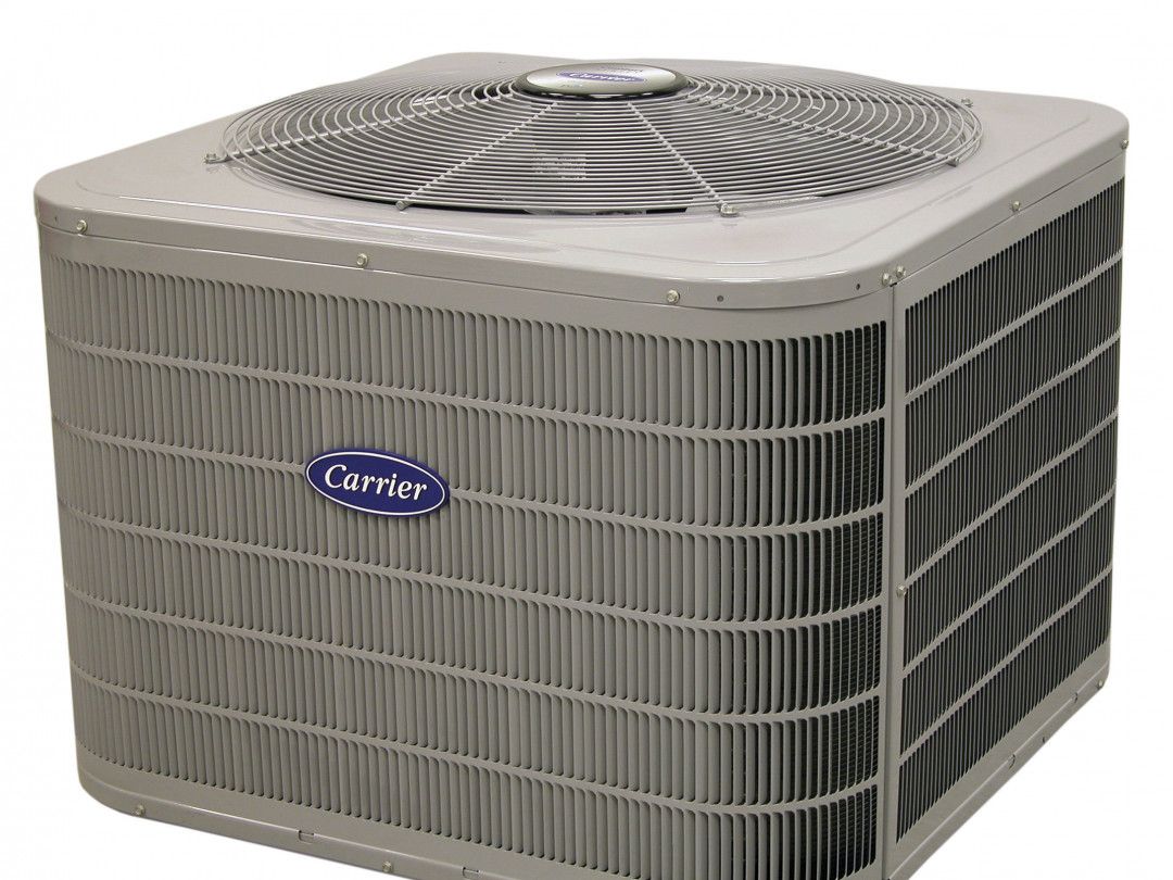 Outdoor Carrier air conditioner unit, gray metal with fan grille on top.