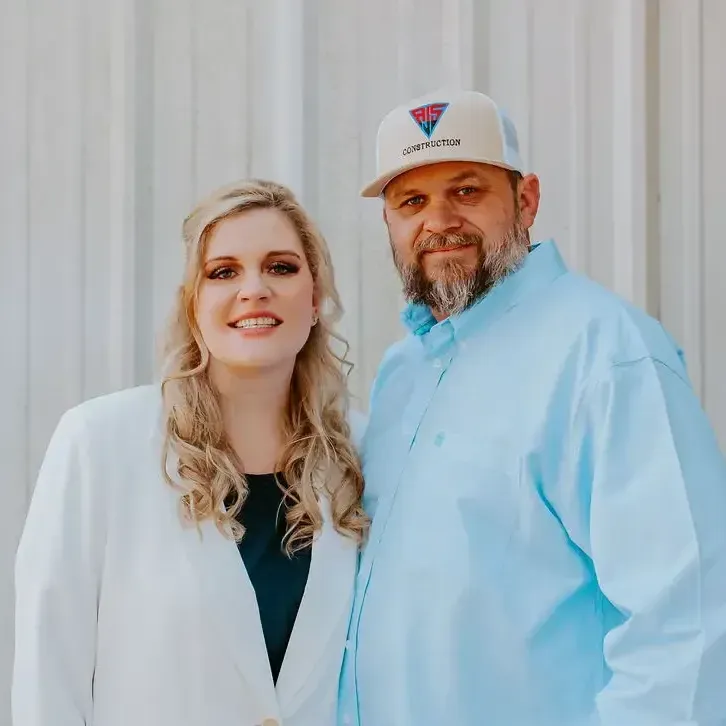 Owners of A&J Remodel and Construction standing together and smiling, showcasing their family-owned Houston remodeling business
