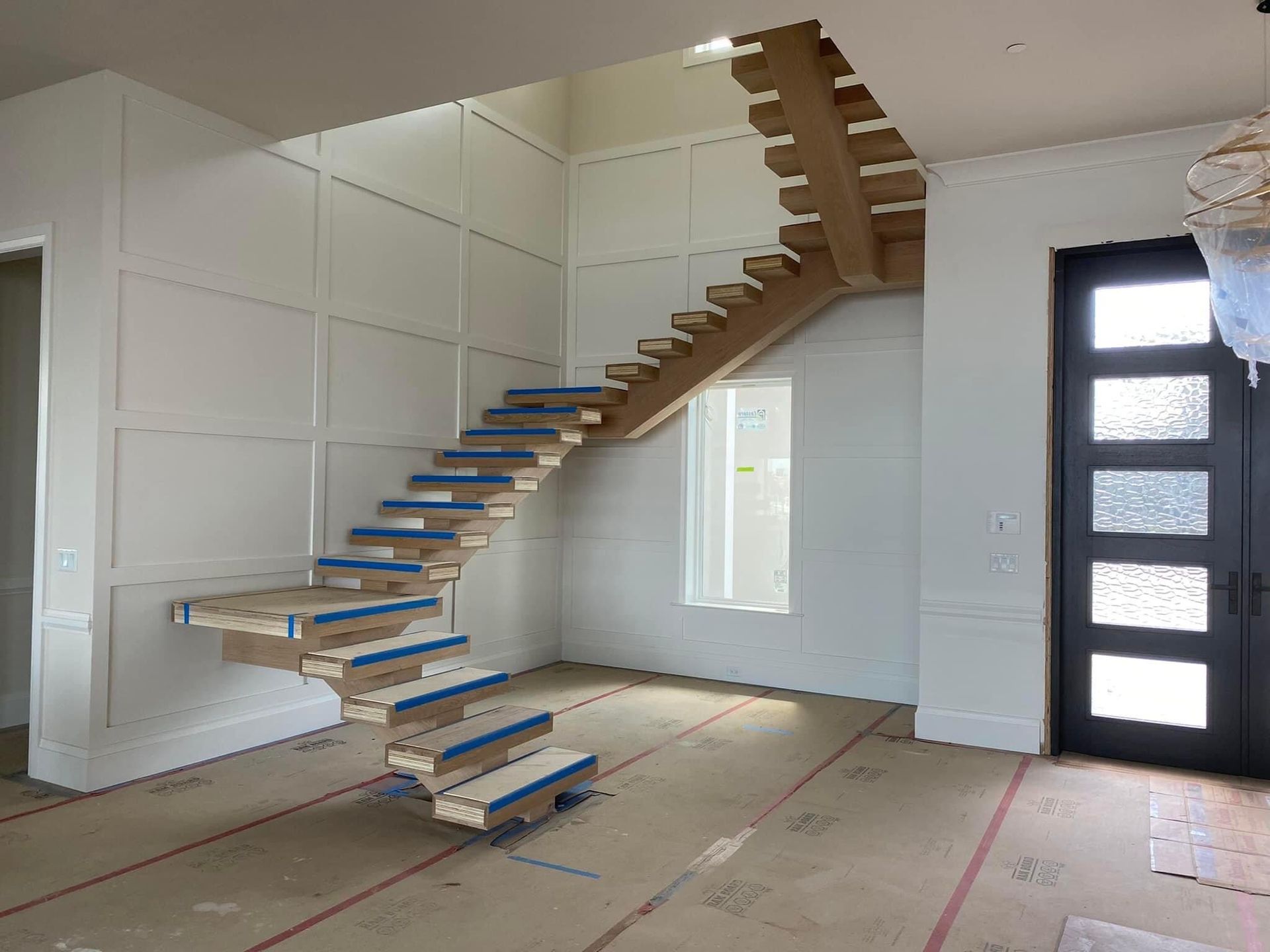 Custom floating staircase with a sleek, modern design and no handrails installed by A&J Remodel and Construction