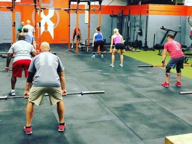a group of people are doing exercises in a gym
