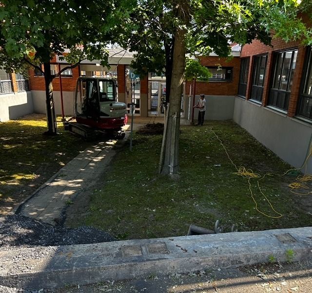 Un tracteur rouge est garé devant un bâtiment