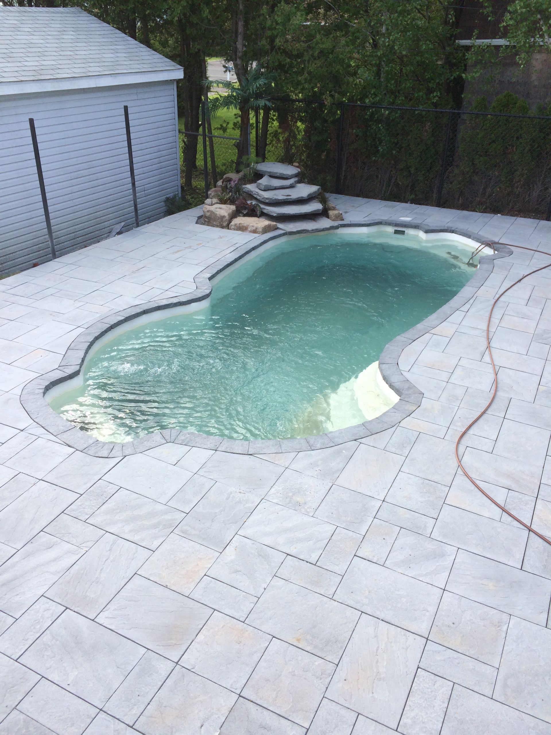 Une grande piscine est située au sommet d'un patio.