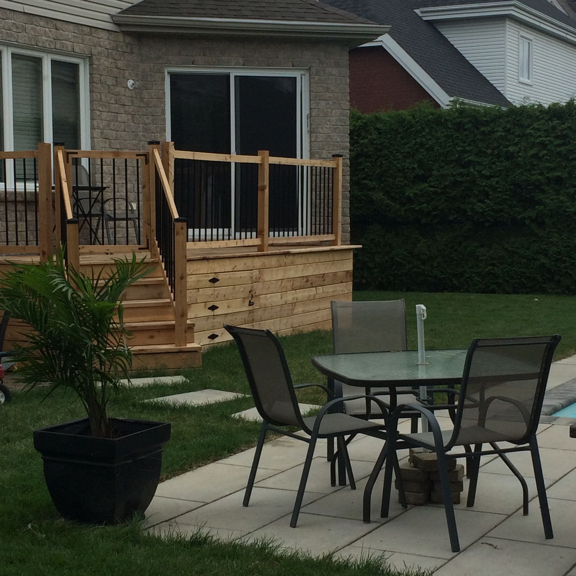 Un patio avec une table et des chaises devant une maison