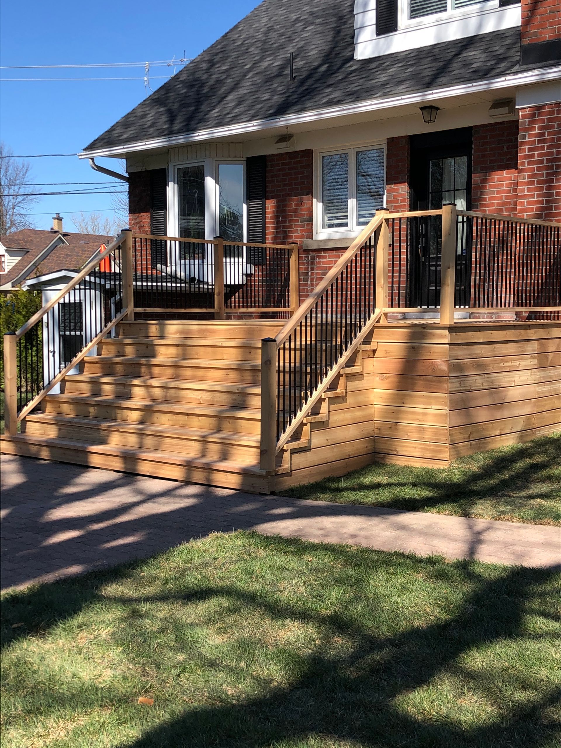 Une maison avec une terrasse en bois et des escaliers devant.
