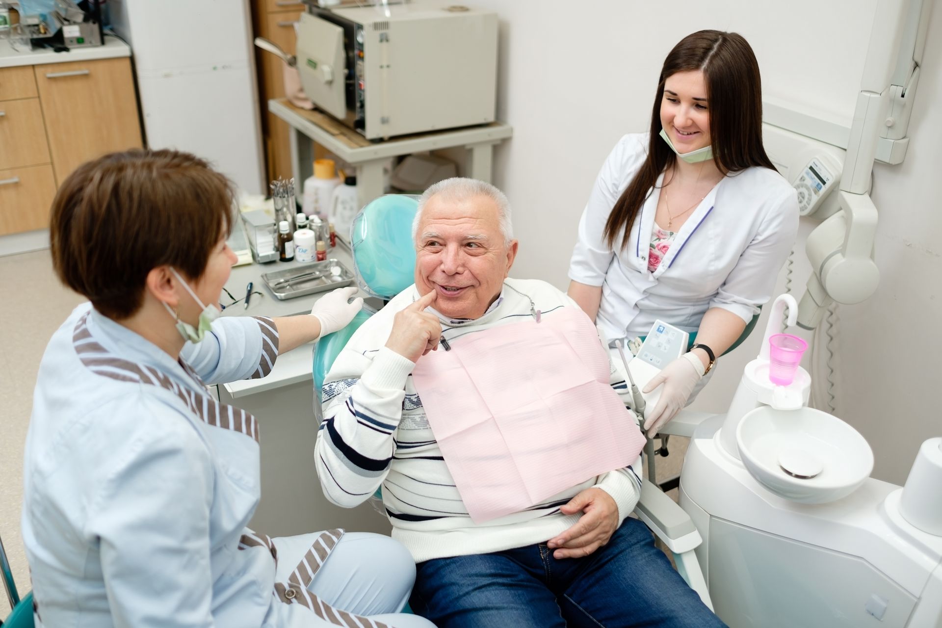 Dentist using a dental tool on a smiling patient in a bright clinic