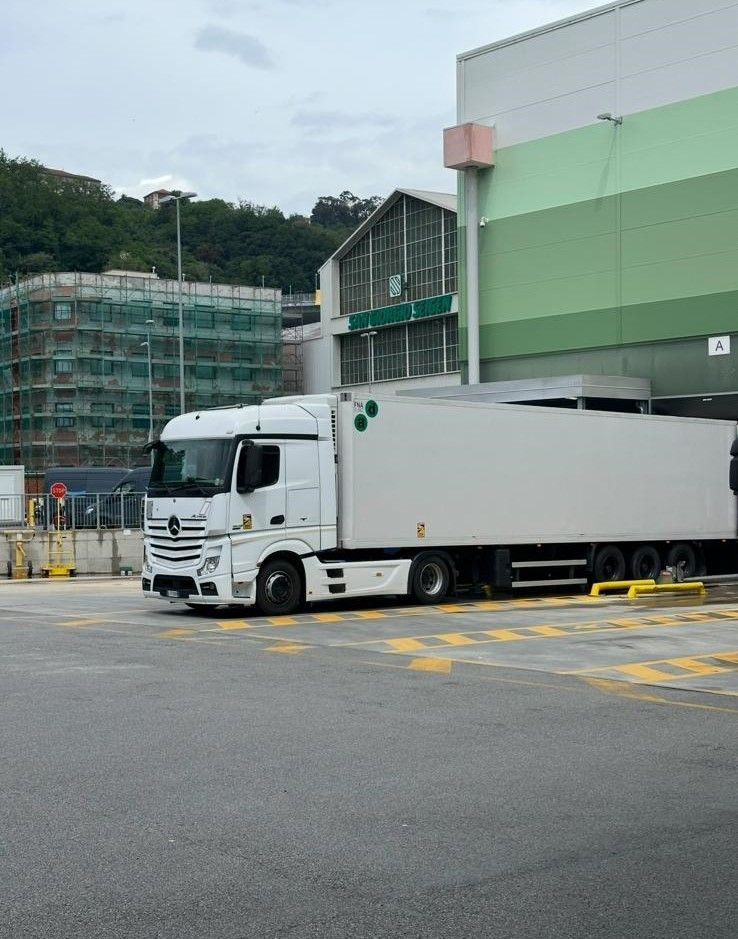 Un camion bianco è parcheggiato davanti a un edificio.