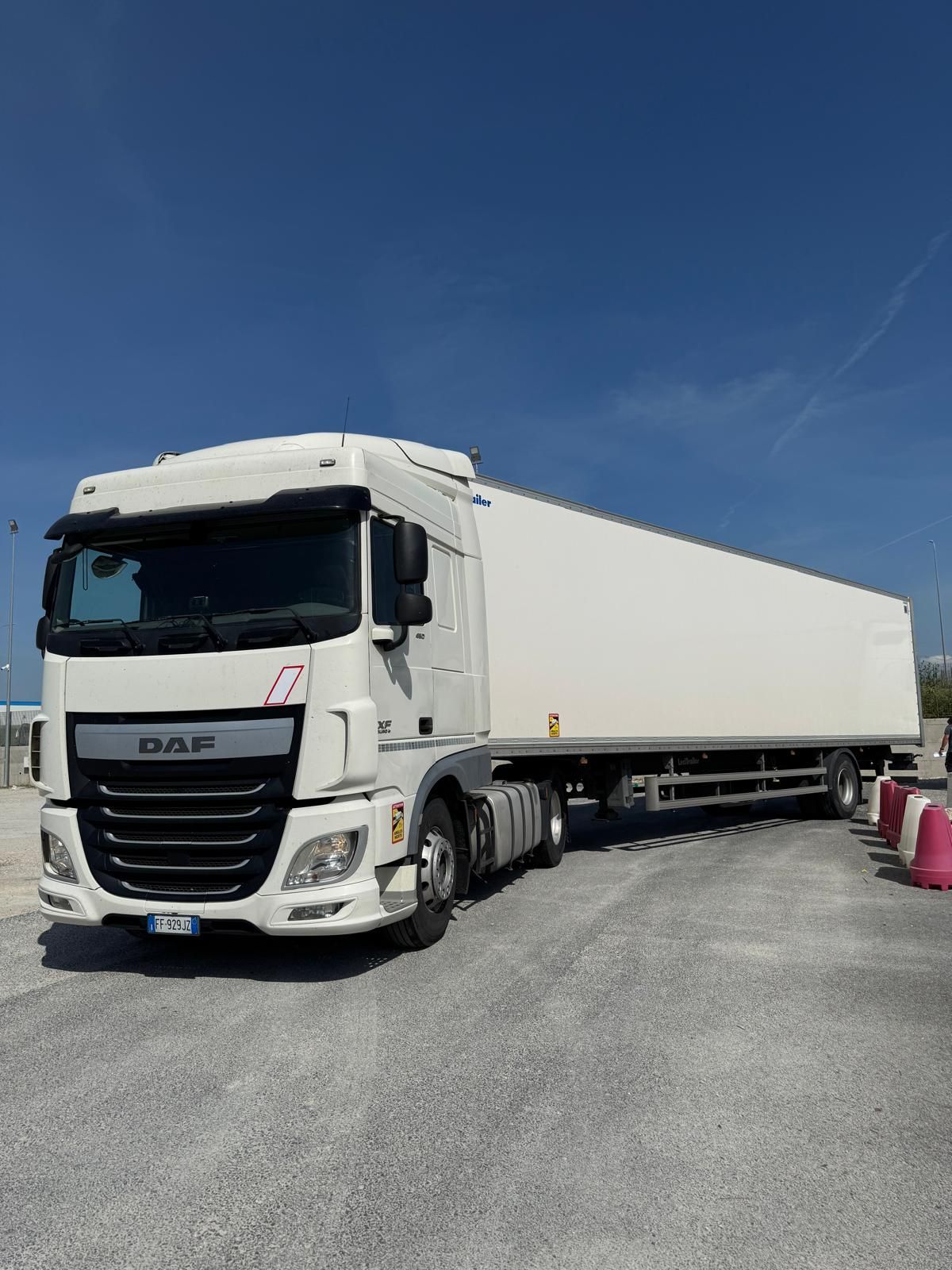 Un camion bianco è parcheggiato in uno spiazzo ghiaioso.