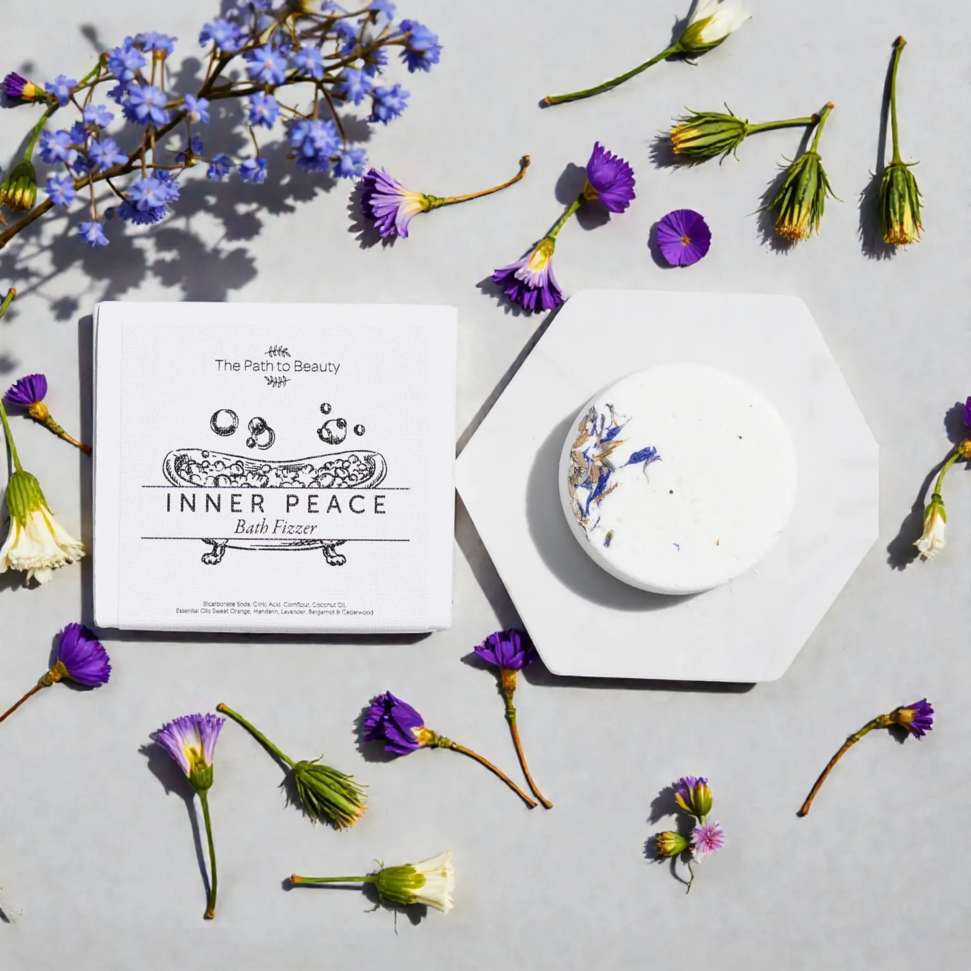 White box and round bath fizzer with purple dried flowers on a light background, labeled “Inner Peace”