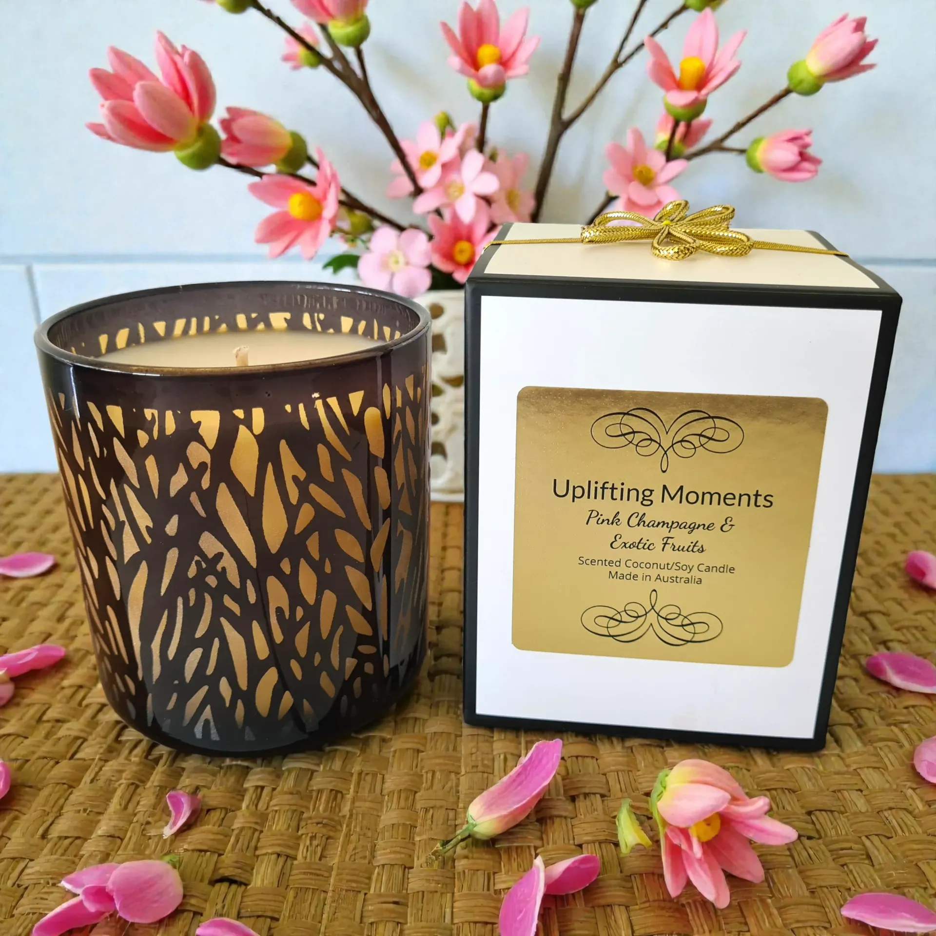 Lacy candle holder on a glossy table beside a pink champagne flute and flowers