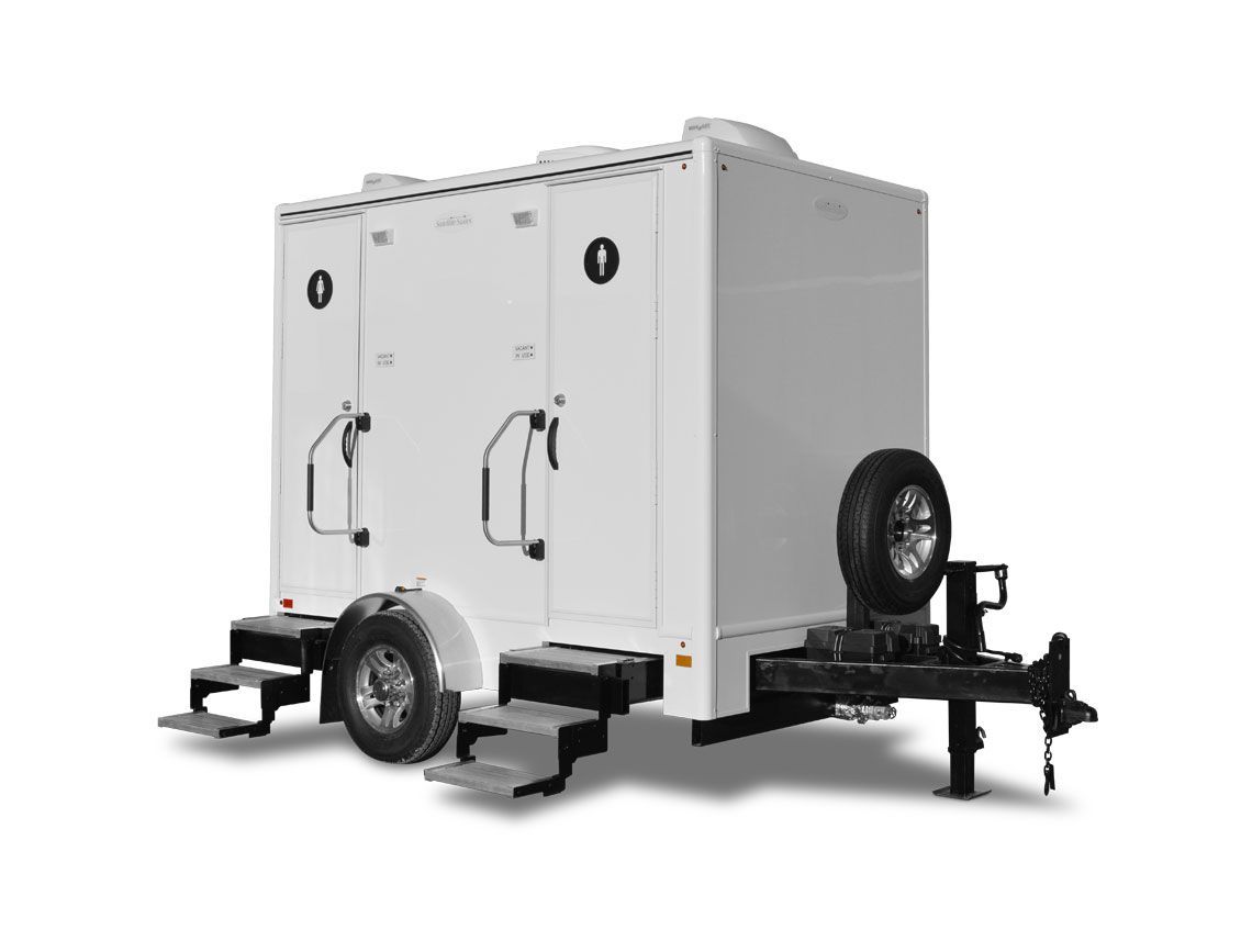 White mobile trailer with enclosed box and spare tire on a black chassis.