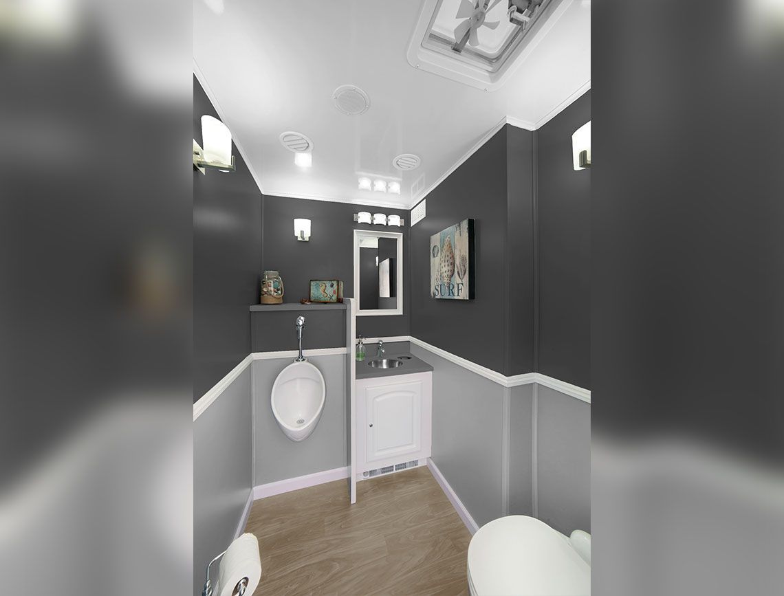 Modern bathroom with dark walls, white wainscoting, wood-look floor, and wall-mounted sink and toilet.