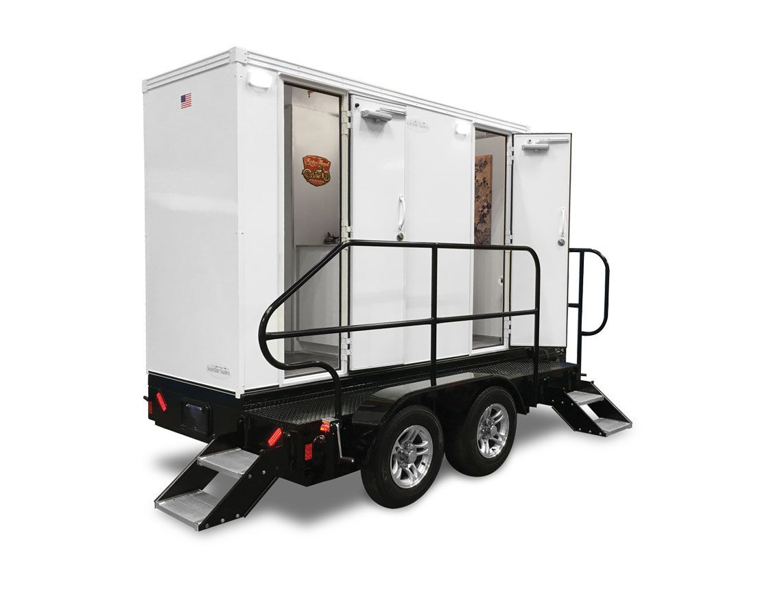 White portable restroom trailer with black railing and stairs on a dual-axle trailer